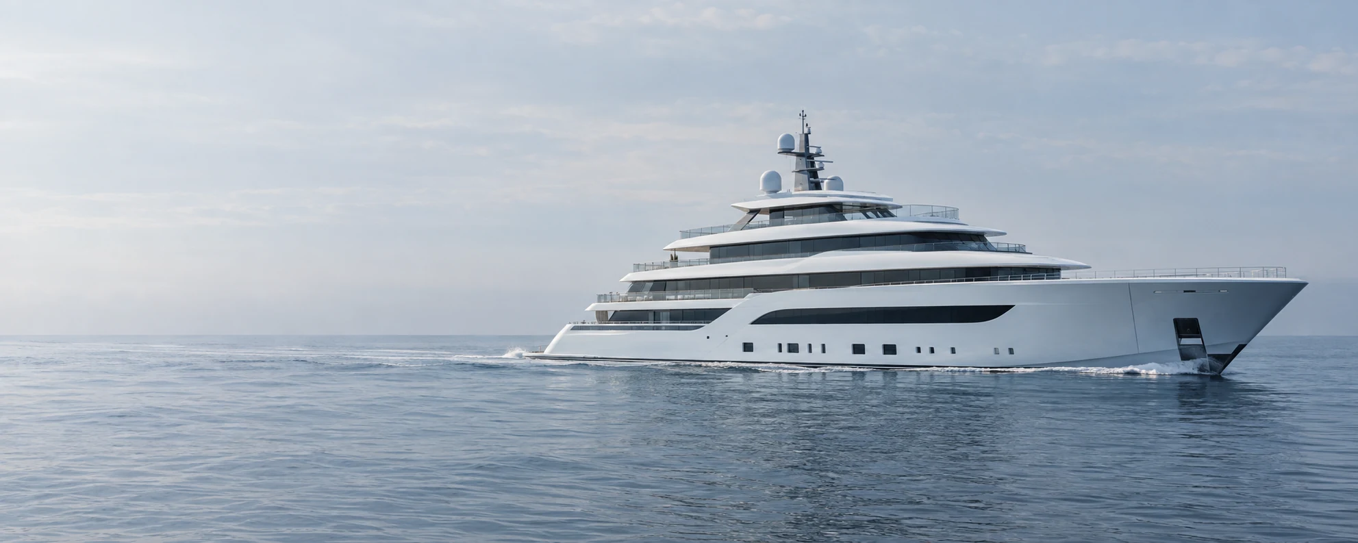 Contemporary white superyacht cruising across calm open water